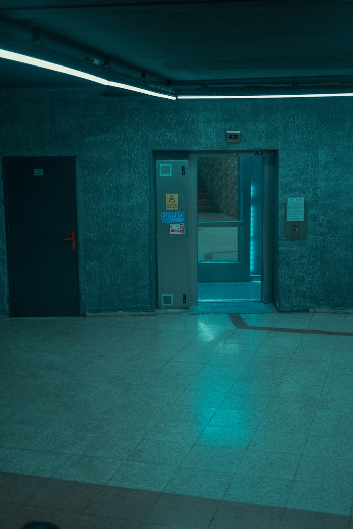 A contemporary elevator with blue lighting in an empty hallway, showcasing modern design in Bursa, Turkey.
